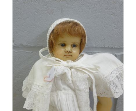 An English poured wax doll, Art Nouveau style faint lozenge motifs to left arm,, a/f thermal damage to head and neck at the b