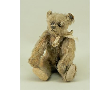 A small Steiff Teddy bear, German circa 1909, the straw filled light brown mohair bear with button to left ear, and black boo