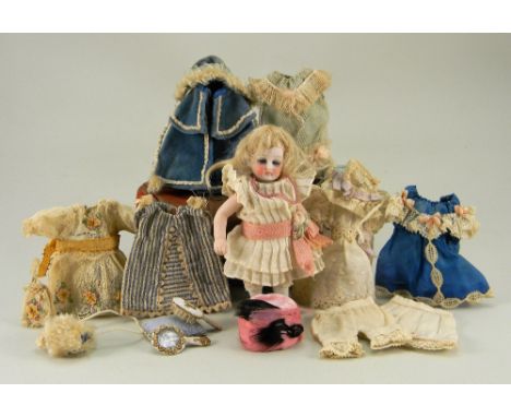 Miniature all-bisque doll with trunk and clothes, German circa 1910, with fixed blue glass eyes, painted lashes and single st