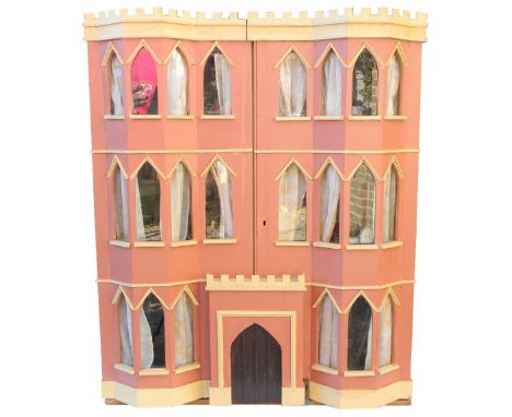 English painted pink wooden dolls house in the Gothic style with contents, the three storey dolls house with full height doub