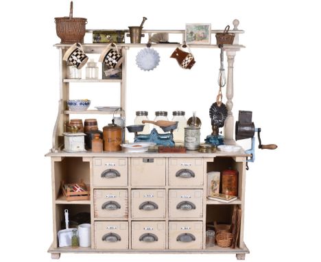 A child’s wooden General store, German circa 1900, cream painted store with blue lining, having nine drawers with ceramic nam