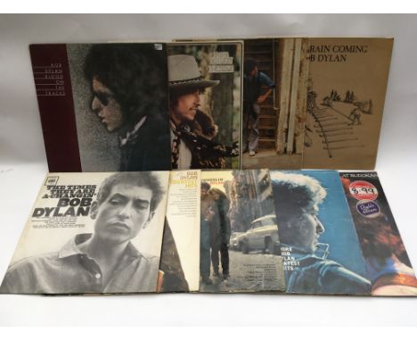 Nine Bob Dylan vinyl LPs including 'Freewheelin', 'The Times They Are A-Changin', 'Blood On The Tracks' and others.