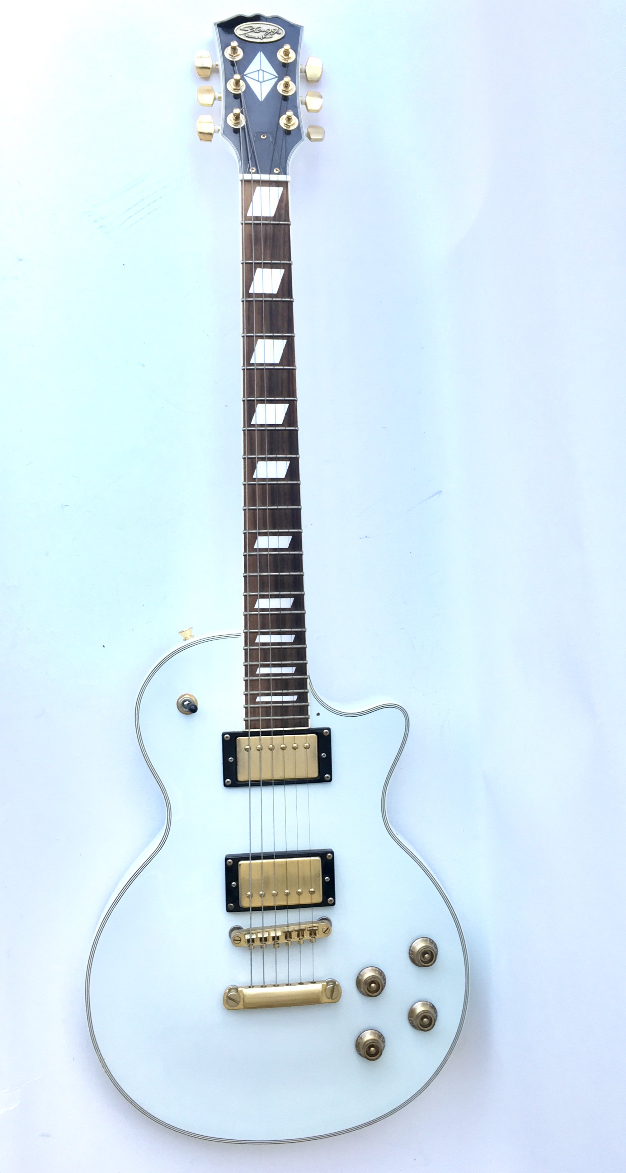 A Stagg Gibson Les Paul shaped electric guitar in white with gold tone