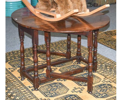 An 18th Century Oak Gate Leg Table, of small proportions, with turned baluster supports and moulded bar stretchers, 118cm by 