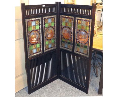 An Arts &amp; Crafts Two Fold Mahogany Screen, with large rounded panels of stained glass, painted with birds and surrounded 