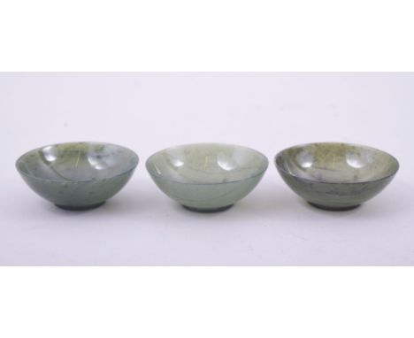 A FINE SET OF THREE CHINESE JADE CUPS, in fitted box, each 7cm diameter.