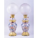 A PAIR OF SAMSON PORCELAIN JAPANESE IMARI AND GILT METAL LAMPS, with globular glass shades, 51cm