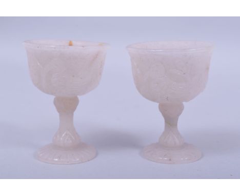A PAIR OF INDIAN MUGHAL CARVED JADE STEM CUPS, carved with birds and flora, 7.5cm high.