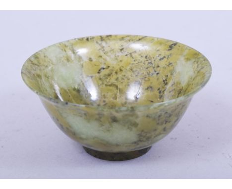 A SMALL CHINESE SPECKLED JADE BOWL, 10cm diameter.