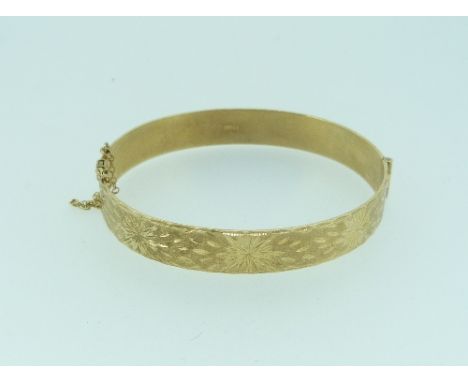 A 9ct yellow gold hinged Bangle, the front engraved with bright cut stars, 19g.