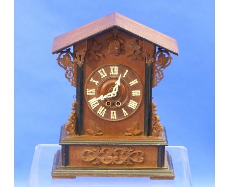 A Black Forest architectural style Cuckoo Mantel Clock, having a pitched roof and with pierced scrolling grapevine decoration