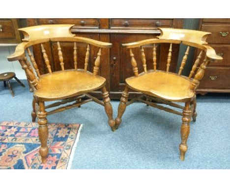 A pair of Victorian ash and elm Smokers bow Armchairs, each with a bowed top rail on bobbin turned supports, shaped arms and 