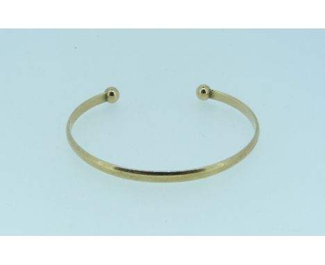 A 9ct yellow gold open Bangle, with two ball finials, approx total weight 8g.