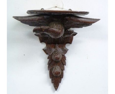 A Black Forest carved Bracket, in the form of an eagle and pomegranates, 18in (46cm) high.