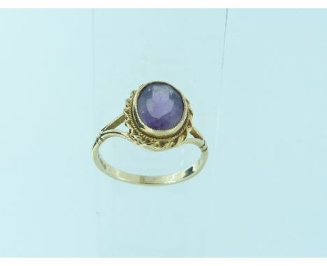 An oval Ring, the centre set with facetted amethyst, with 9ct yellow gold shank and ropework border, Size M½, together with a