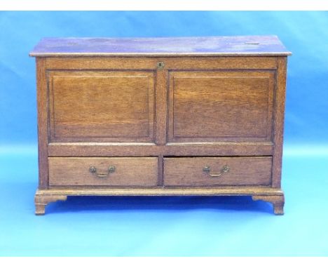 A Georgian oak Mule Chest, with hinged plank top above twin fielded panels and two drawers beneath, raised on bracket feet, 5