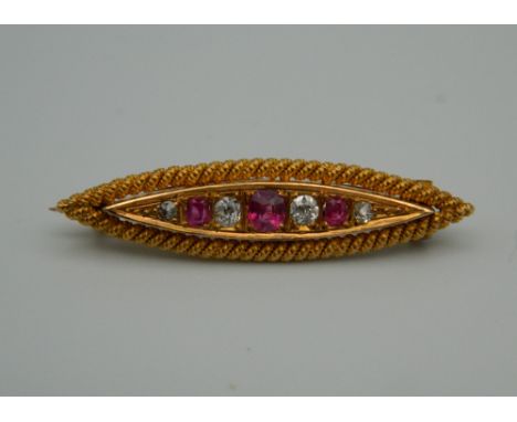 An unmarked gold diamond and ruby navette form brooch. 3.5 cm wide. 3.8 grammes total weight.