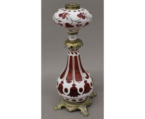 A Victorian brass mounted cranberry flashed glass oil lamp. 40 cm high.