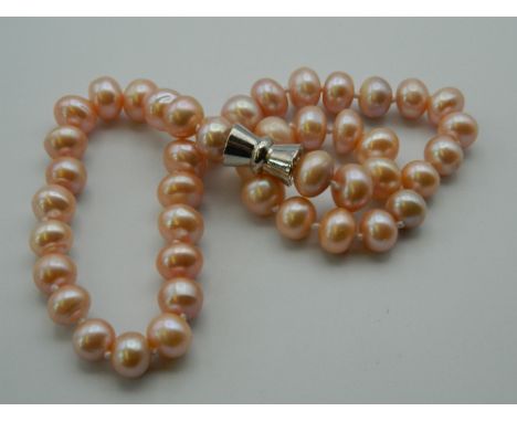 A pink pearl bead necklace. 46 cm long.