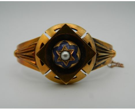 A unmarked gold enamel and pearl set bangle form bracelet. 6 cm wide. 17.9 grammes total weight.