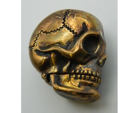 A brass vesta formed as a skull. 4 cm high.
