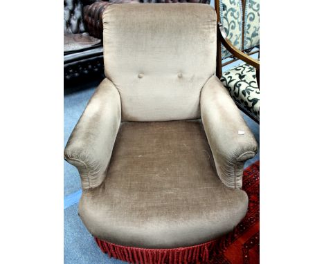 A LATE VICTORIAN UPHOLSTERED LOUNGE ARMCHAIR with turned walnut supports and brass and ceramic castors, 80cm wide at the arms