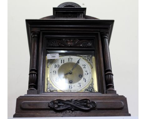 A LATE 19TH / EARLY 20TH CENTURY WALNUT CASED MANTLE CLOCK with shaped pediment and carved pilaster columns, standing on brac