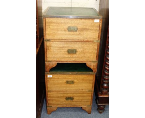 A PAIR OF TEAK AND BRASS MOUNTED BEDSIDE CHESTS each with green leather inset tops, two drawers, brass campaign handles and b