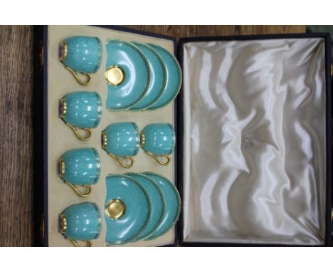 AN EARLY 20TH CENTURY CASED SET OF ROYAL WORCESTER COFFEE CANS AND SAUCERS decorated with a gilt greek key pattern on a green