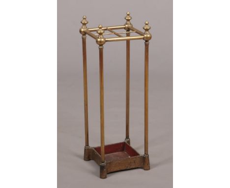 An Edwardian small brass stick stand. With turned finials and raised on an iron base, 67cm high.  