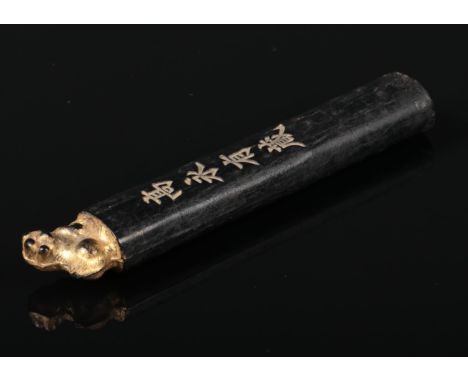 A 19th century Chinese calligraphy ink stick. With a gilt decorated dog of fo finial and incised four character mark, 8cm.  G