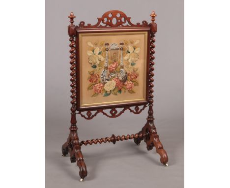 A large Victorian rosewood firescreen with square bead and woolwork panel under gilt frame. With open fret carved pediment, t