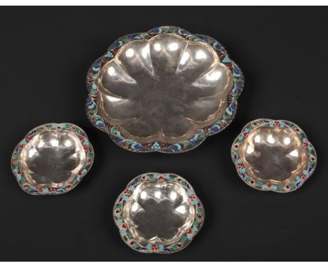 A set of four early 20th century Russian style lobed silver dishes. Planished, with champleve enamel borders and raised on bu