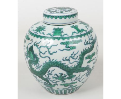 A Chinese ginger jar and cover. Painted in underglaze blue and green with three dragons chasing flaming pearls on grounds of 