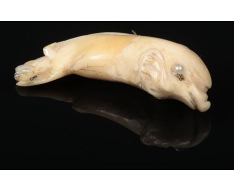 A 19th century carved ivory, gold and seed pearl mounted pendant formed as a dolphin, 4.5cm.  Some repair to the tail. Fittin