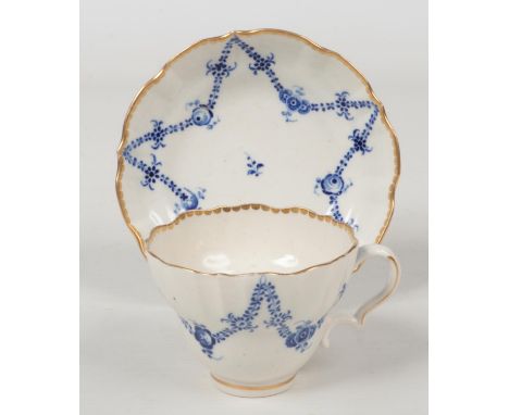 A rare Caughley coffee cup and saucer of ogee form and with scalloped rims embellished with gilt dentil borders. Painted in b