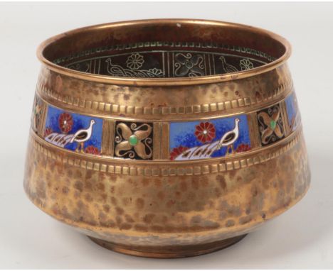 A WMF small planished brass planter. With an enamelled band depicting peacocks interspersed with rosettes. Impressed mark to 