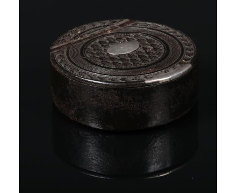 A Georgian carved ebony and silver mounted snuff box of circular form and with hinged cover, 4.75cm diameter.  