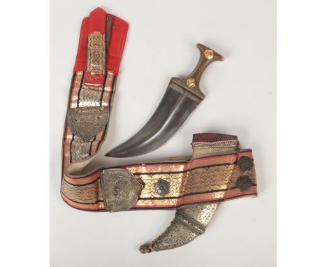 A Janbaya dagger with picquet inlaid horn grip and in scabbard on sash. The sash decorated with red and gold embroidery and p