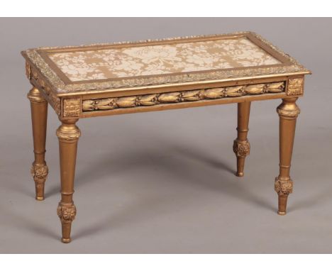 An early-mid 20th century giltwood side table with glass top and raised on tapering supports, 64cm x 32cm, 40cm high.  Some s