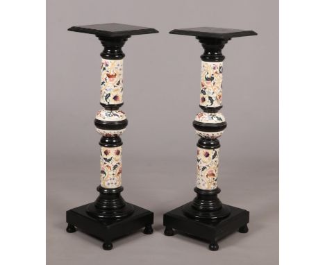 A pair of Hungarian Zsolnay pottery and ebonised wood torcheres. With knopped pedestals and raised on square plinths over bal