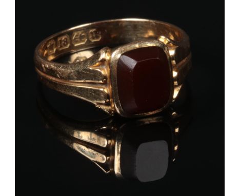 A Victorian 18 carat gold carnelian signet ring. Set with a cushion shaped tablet on reeded spreading shoulders. Assayed Birm