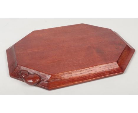 A Robert Thompson Mouseman cheeseboard of canted rectangular form. With adzed top and carved with a mouse to one side, 31cm w