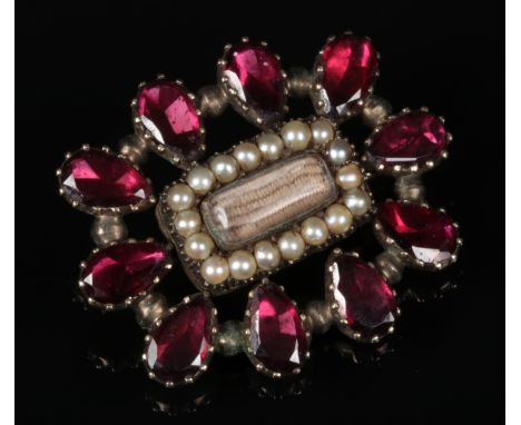 A Regency garnet and pearl mourning brooch with plait centre panel, 28mm wide.  Good condition.