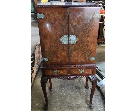 A walnut mirrored back cocktail cabinet with decorative fittings, 2 drawers and cabriole legs. 60cms w x 44cms d x 131cms h.C