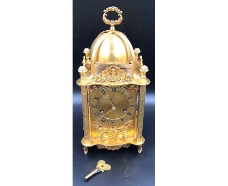 A large decorative lantern clock with key and pendulum. 39cms h to carry handles 18cms w.Condition ReportVery good condition.