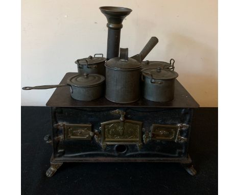 A vintage child's tinplate stove and pans. 24 x 16cms.Condition ReportGood condition.