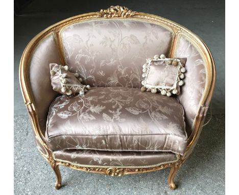 A 19thc carved gilded wooden framed single seat sofa with floral upholstery and a pair of tassel cushions. Height to seat 50c