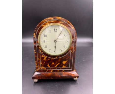 A tortoiseshell mantle clock, 20.5cms h, white metal string inlay.Condition ReportLacking inlay to front approx 10cms. Slight