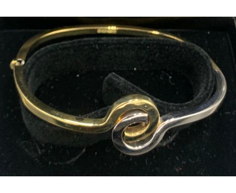 A 9ct yellow and white gold hinged bangle. 6.7gms.Condition ReportGood condition